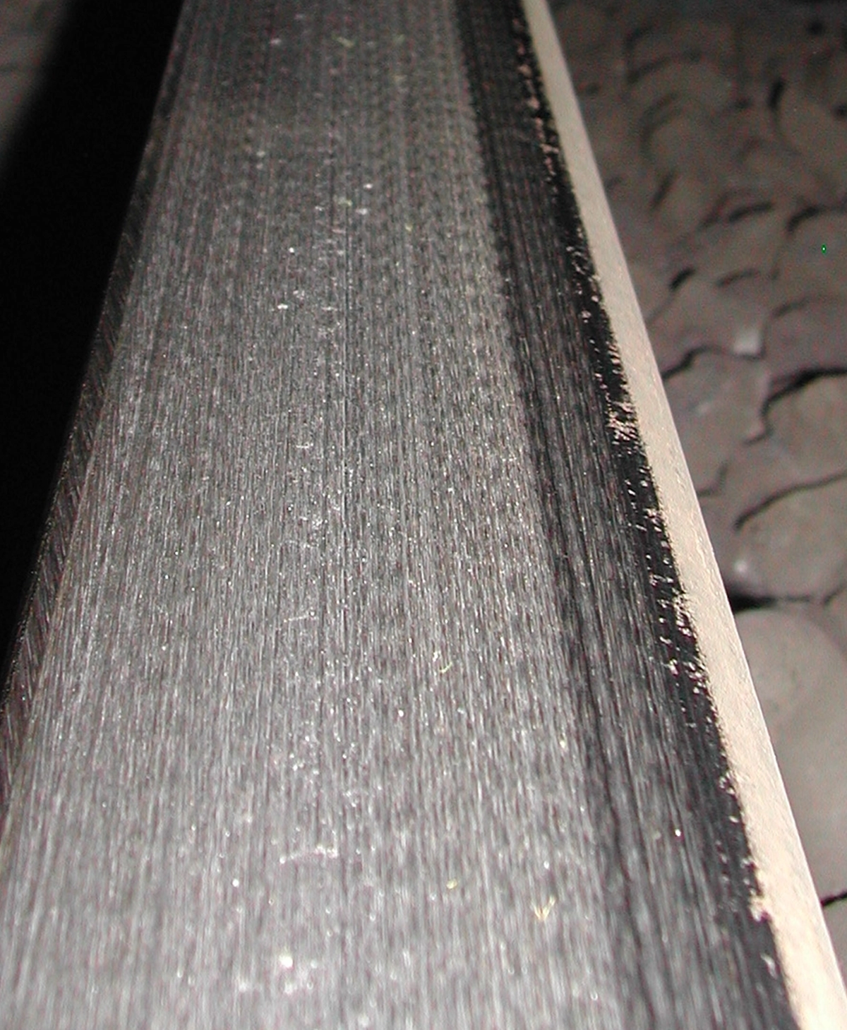 Rail that has been ground to leave longitudinal scratches, minimal periodicity and low roughness